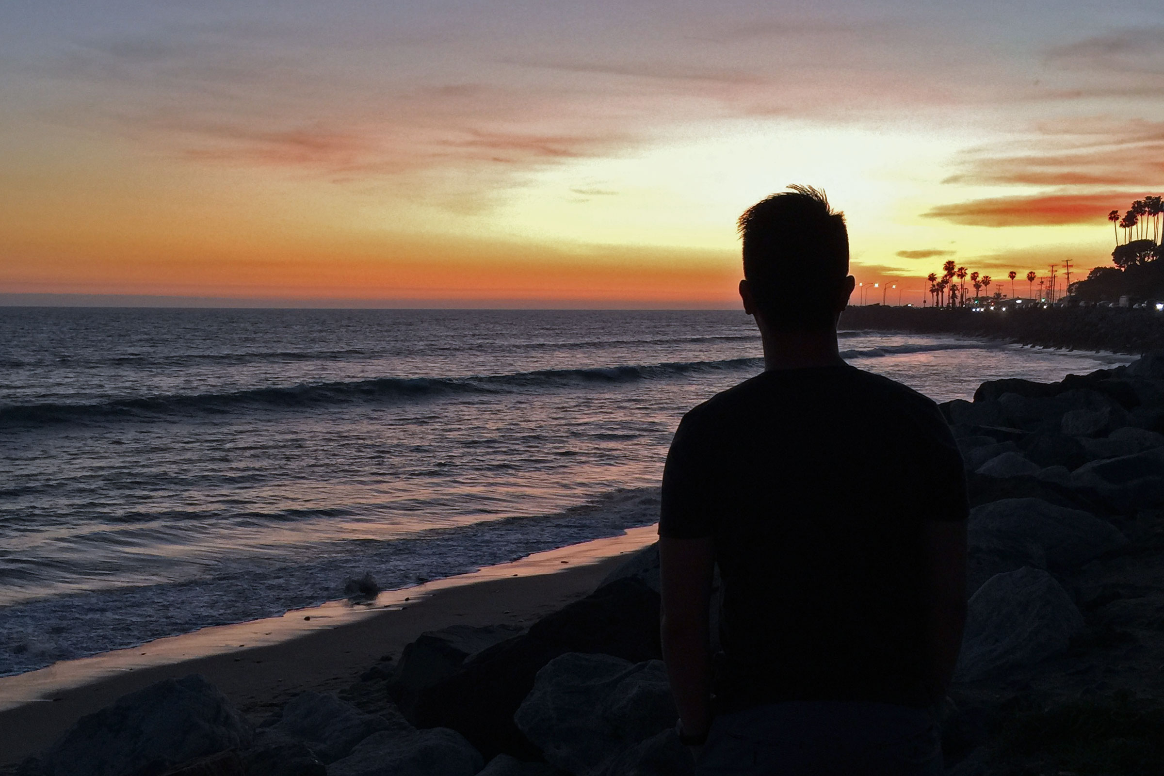Brad Yau overlooking the Pacific Ocean at sunset